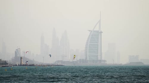 Panoramic view of the Dubai Skyline and the Burj Al Arab as Kite surfers enjoy the day at Fazza beac
