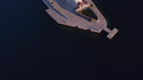 Aufnahme von oben auf die Heilige Kirche Unserer Lieben Frau von den Felsen in der Bucht von Kotor bei Sonnenaufgang, Luftaufnahme