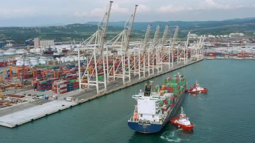 Aerial view of a cargo container ship leaving the port.