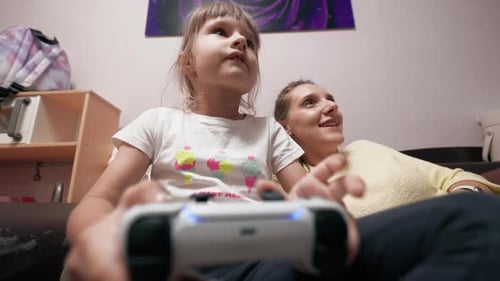 Girl Playing Video Game with Mom
