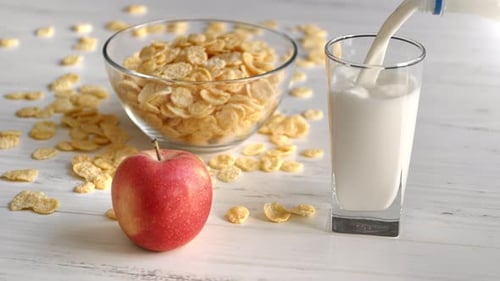 Pouring Milk for Breakfast with Corn Flakes