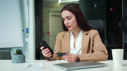 Business Lady with Bank Card and Mobile Having Problems with Online Payment