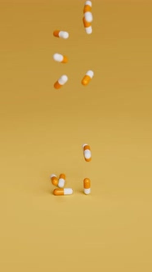 Pilules blanches et oranges tombant sur fond orange au ralenti Médicaments Pilules Comprimés Médicaments