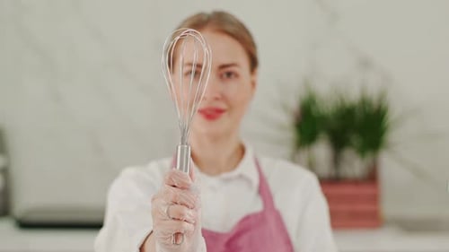 Woman Holding Whisk in Kitchen Close Up