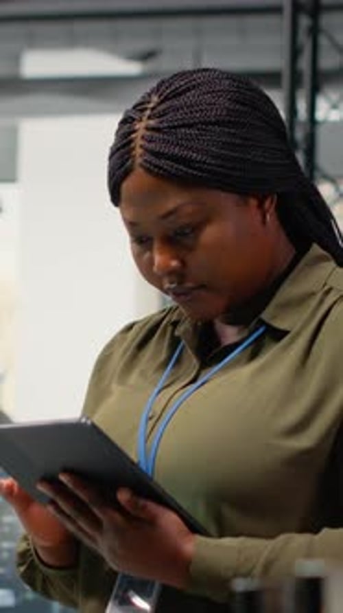 Вертикальный видеопортрет улыбающегося инженера, работающего в офисе с использованием специализированного оборудования искусственного интеллекта