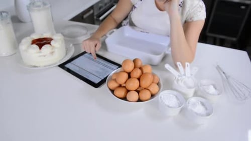 Woman Using Tablet for Baking Recipe in Kitchen