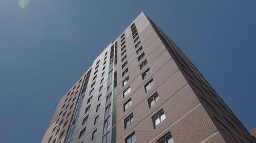 Low Angle View of Modern Residential Apartment Tower Against Blue Sky
