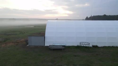 white arched hall in dawn on farm in poland sunrise aerial circulating