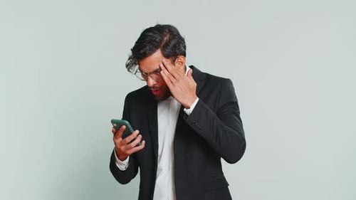 Frustrated Man in Suit Using Cellphone