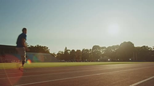 Athletic Disabled Fit Man with Prosthetic Running Blades is Training on Outdoors Stadium on Sunny A