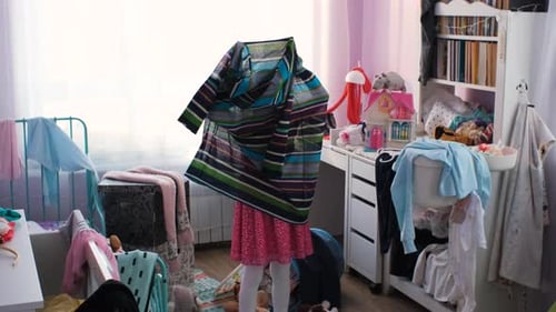 Menina se diverte enquanto experimenta o vestido da mãe