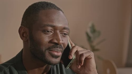 Handsome Black Man Talking on Mobile Phone at Home Office