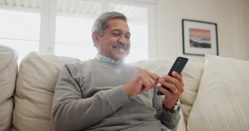 Senior, happy man and typing in home with phone, scroll social media or reading mobile news article