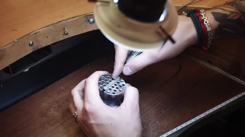 Man Uses Drill on Metal Piece Close Up