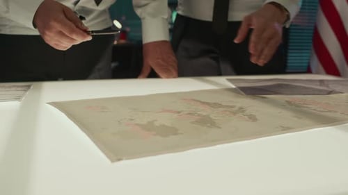 Men Pointing at Map During Strategy Meeting