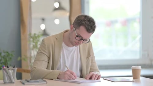 Young Businessman Doing Paperwork in Office