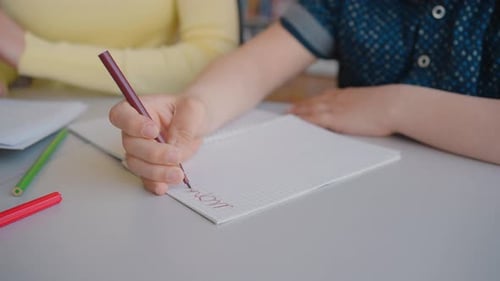 Student Learning and Writing in Classroom with Teacher