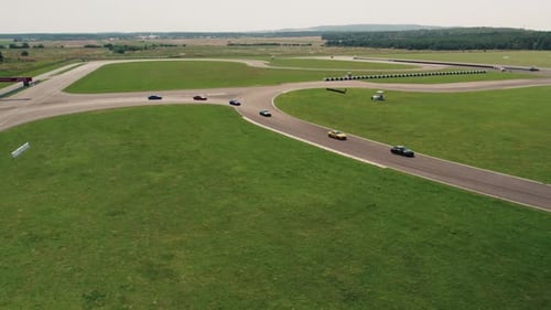 4k Drone Shot of Race Track and Sport Cars Driving Slowly on Sunny Day