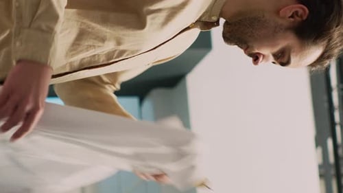 Man Organizes Shirts in Wardrobe Indoors