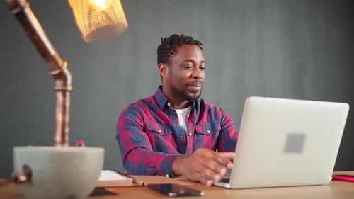 Man working on laptop, participating in video call
