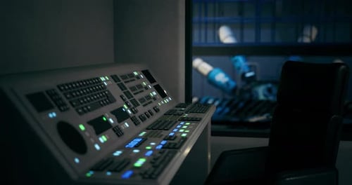 Control Panel in an Industrial Setting with Robotic Machinery in Background