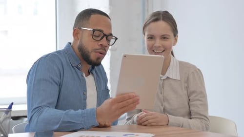 Colleagues Video Conferencing With Tablet In Office