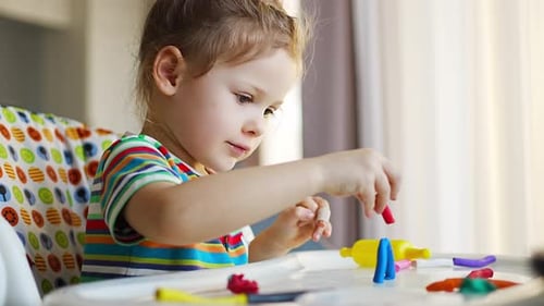 Child Playing with Colorful Clay Indoors