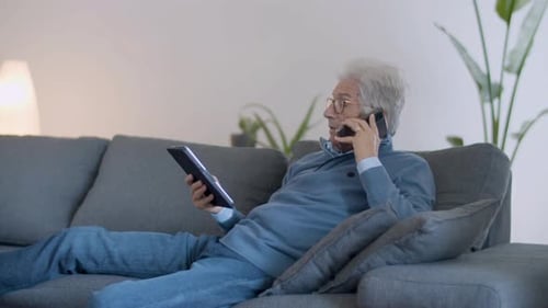 Senior Man on Couch with Tablet and Smartphone