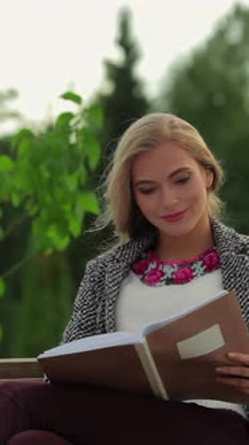 Charming Girl Student Immersed in Reading on a Sunlit Park Bench