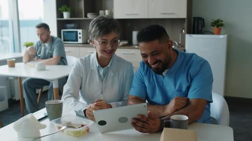 Medical Professionals Using a Tablet in Break Room