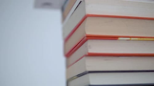 Close-up of the books at the stake. Smooth movement from top to bottom. Colourful book covers and bo