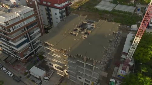 Vista aérea de una gran obra de construcción con trabajadores y máquinas que preparan activamente los cimientos