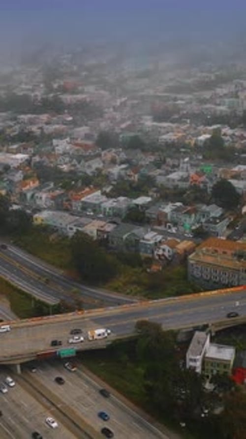 City panorama with busy traffic and lively streets. San Francisco scenery coating with fog.