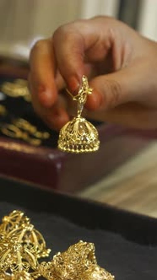 Female customer shopping for 22k hallmarked gold jewellery at a shop, Gold investment, vertical shot