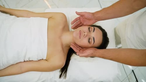 Spa Therapist Providing a Rejuvenating Facial Massage to a Woman