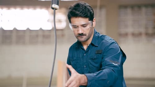 Professional Carpenter Examining Wooden Plank in Workshop