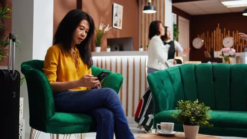 Woman in Hotel Lobby Using Cell Phone