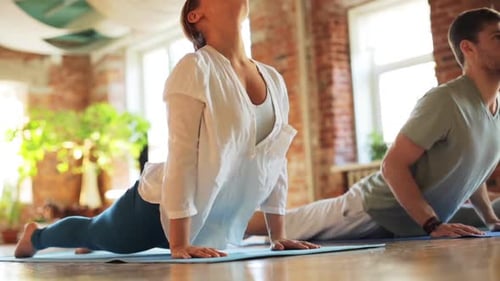 People Doing Yoga Exercises on Mats in Studio