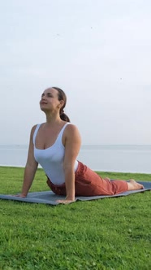 Asana de yoga matinal d'une jeune femme en plein air