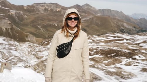 Hiker Redhead Woman Standing on Top of a Mountain Peak Looking at Snowy Austrian Alps