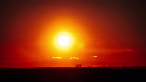 Zeitraffer eines Dramatisch Sonnenuntergangs mit Sonnenstrahlen am Himmel durch orangefarbene Wolken