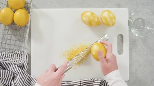 Hands Zesting a Bright Yellow Lemon