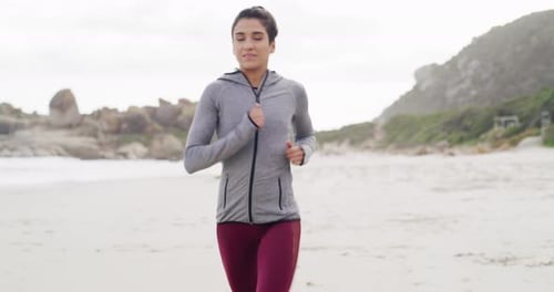 4k video footage of an attractive young sportswoman running on the beach