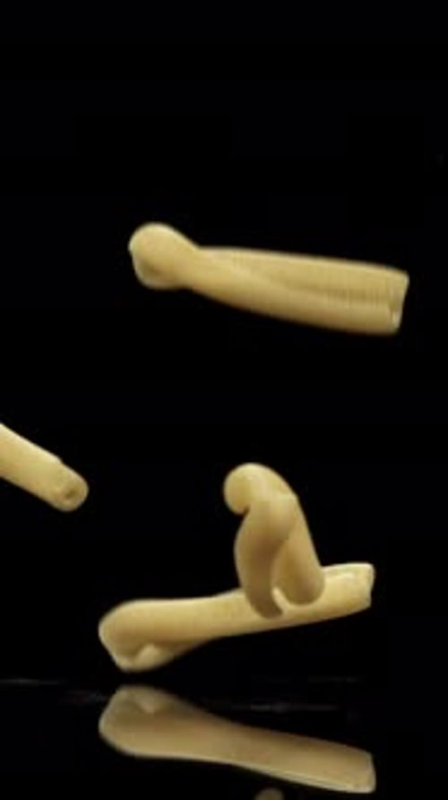 Dry Pasta Falls on the Black Table Filmed on a Highspeed Camera at 1000 Fps