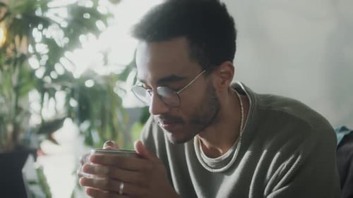 Young Adult Drinking from a Mug Indoors