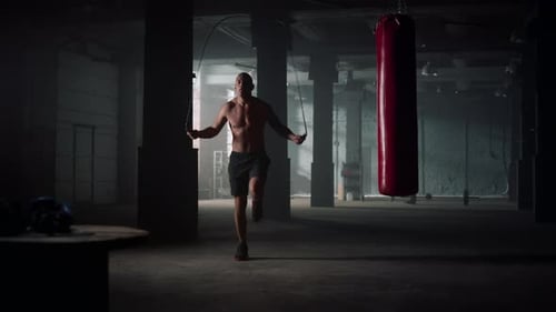 African American Man Jumping with Skipping Rope Before Training in Gym. Muscular