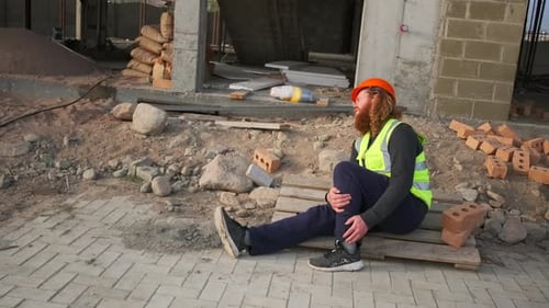 Injured Construction Worker Sitting on Pallet