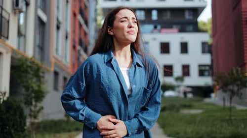 Woman Suffering From Stomach Cramps On The Street