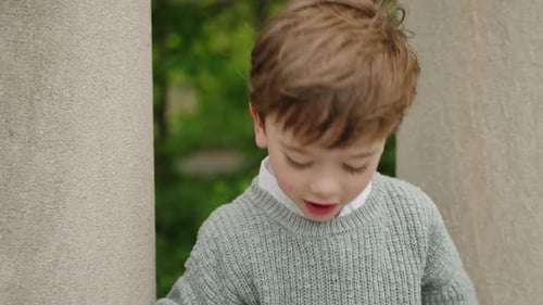 A young boy is running and playing in the garden and having a lot of fun