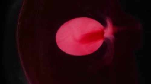 Red Liquid Swirling in White Receptacle